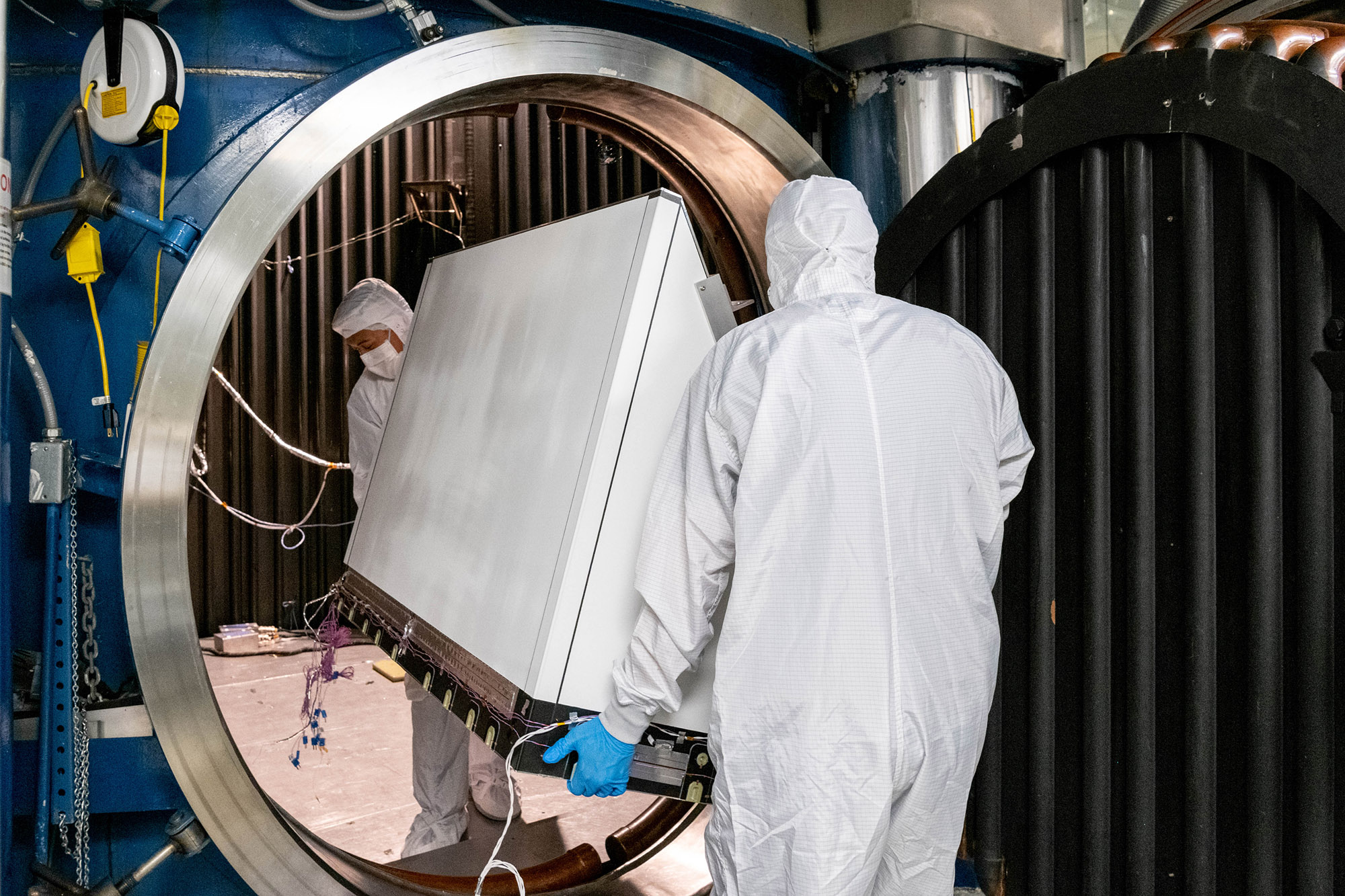 Mechanical Technicians Daniel Dizon and Joseph Eddy transport the Ocean Color Instrument Earth Shade into the thermal vacuum chamber.