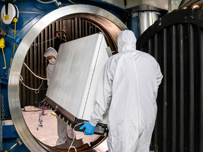 Mechanical Technicians Daniel Dizon and Joseph Eddy transport the Ocean Color Instrument Earth Shade into the thermal vacuum chamber.