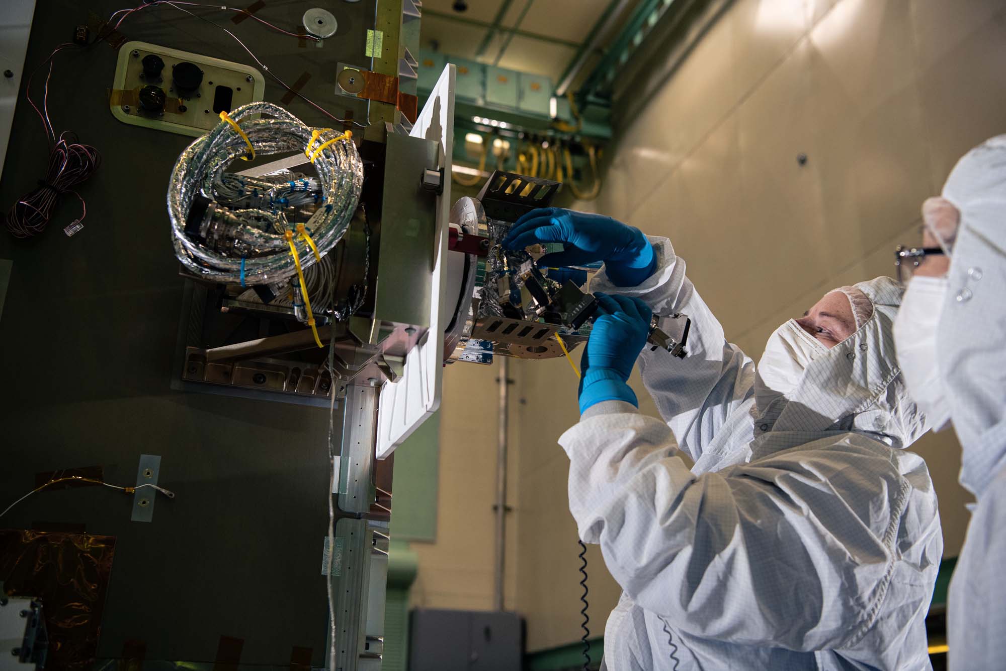 Installing the solar array drive assembly on the PACE spacecraft bus.