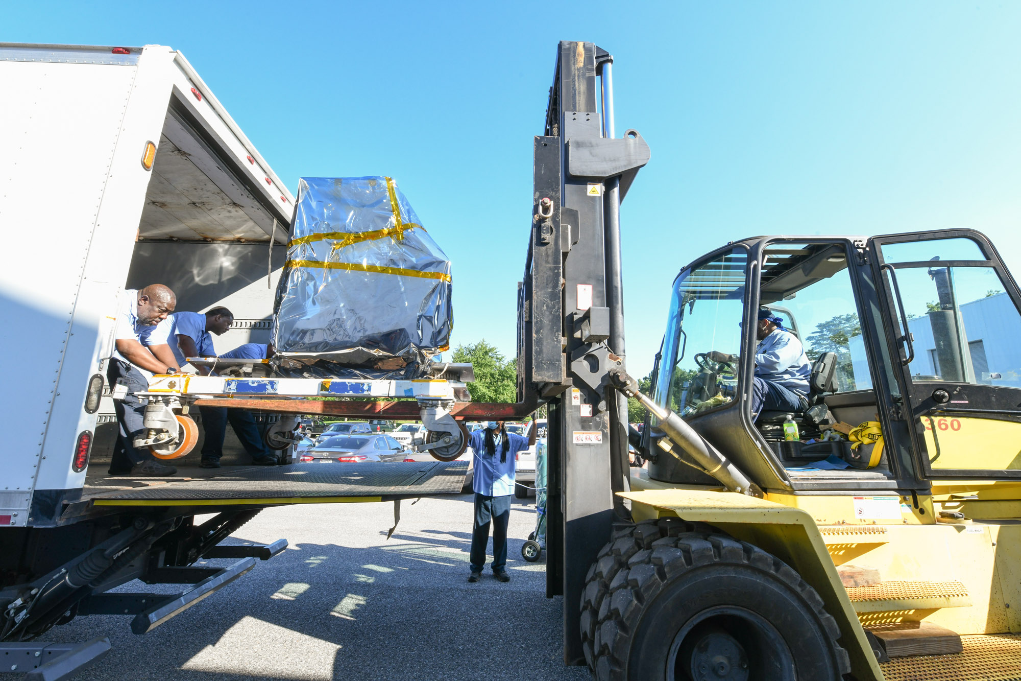 The GSFC Trax team lifts the Ocean Color Instrument on a forklift into a truck to transport to the integration and testing facility for envirnomental testing.