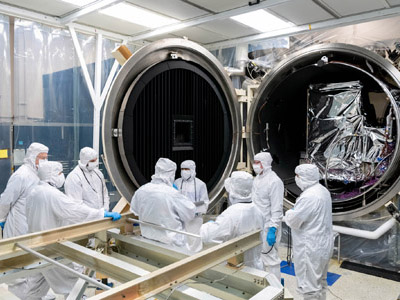 The Ocean Color Instrument team evaluates the instrument configuration in the Thermal Vacuum Chamber (TVAC) prior to closing the chamber door for testing. Credit: Mellos, Katherine