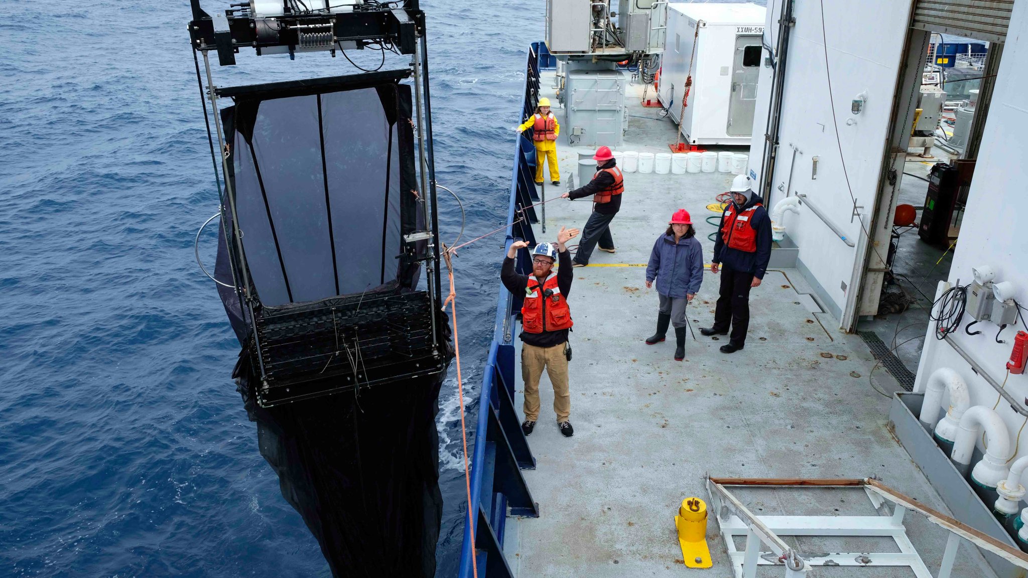 The Multiple Opening/Closing Net and Environmental Sensing System (MOCNESS) is deployed off the bow of the R/V <em>Roger Revelle</em>. This specialized net, which incorporates many different smaller nets, is towed behind a vessel, and enables the collection of plankton throughout the water column.